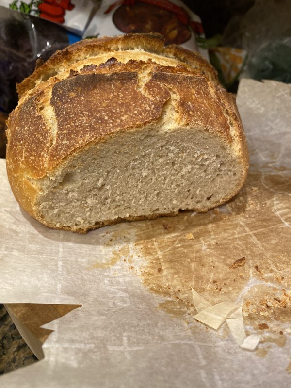 A dark-crusted loaf cut across the middle showing a tight, close crumb